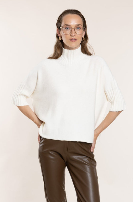 White sweater with ribbed trim.