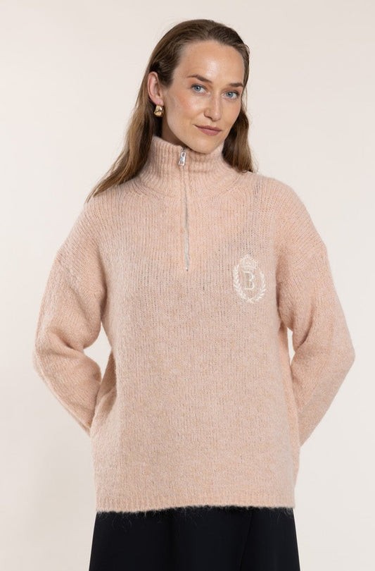 Peach-colored sweater with a high collar.